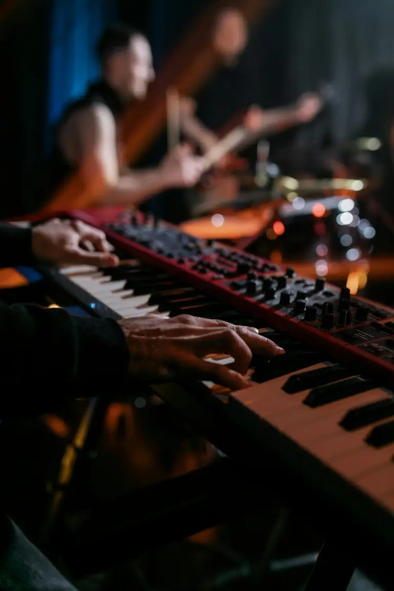 Musician's hands skillfully playing an electronic keyboard during a live band performance on stage.